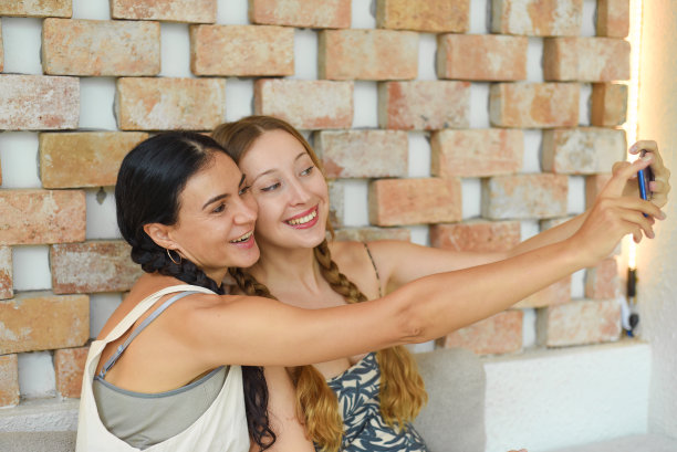 乌克兰女子(黑发)和俄罗斯女子(金发)梳着辫子摆姿势自拍图片下载