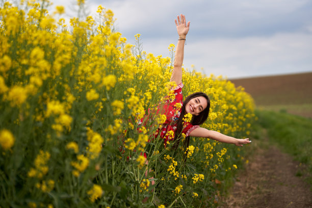 穿着花裙的拉丁美女站在油菜地里图片下载