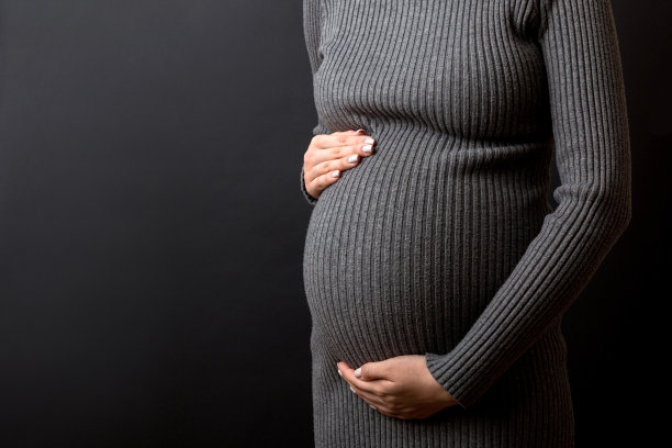 一个肚子疼的怀孕女孩站在彩色背景上。孤立的图片下载