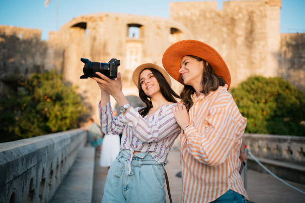年轻女子在拍摄令人惊叹的古老建筑的照片图片下载