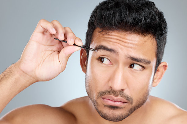 一个帅哥在用镊子夹眉毛图片下载