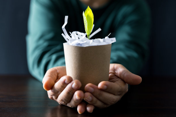 一位对环境可持续发展充满热情的女士致力于通过回收纸张来保护树木，为更绿色的未来做出贡献。她的行为体现了生态意识。图片下载