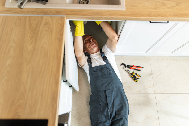 水管工正在修理厨房里的水槽图片下载