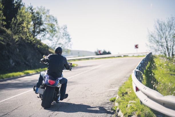 一个人在山路上骑摩托车。图片下载