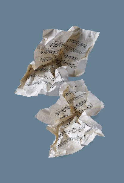 两张皱巴巴的音乐纸在蓝色背景上飞舞，一张抽象的照片图片下载