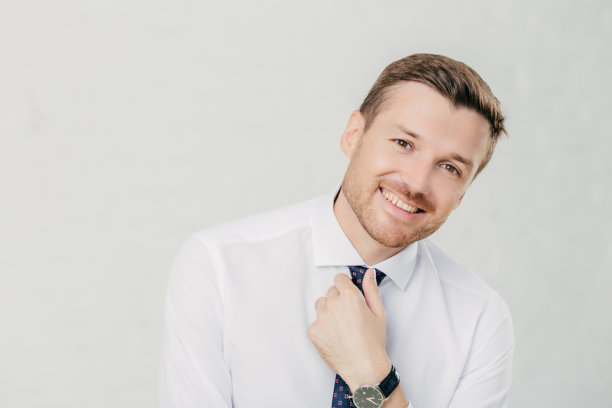 开朗的男领导穿着优雅的白衬衫，手系领带，开心地笑着。孤立在白色背景上。图片下载