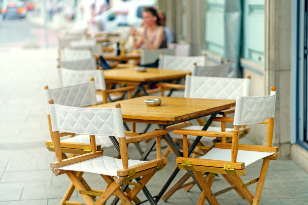 街边餐馆用木头做成的折叠桌椅矗立在人行道上图片下载
