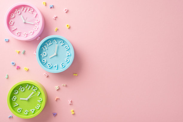 欢迎回到学校。俯视图字母和三个时钟设置为不同的时间，表示课程安排。粉彩粉色背景与空白空间的文字或广告的目的图片下载