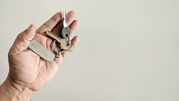 一个男人手里拿着两把钥匙和一个钥匙链图片下载