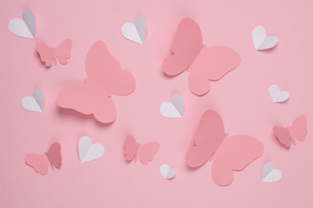 蝴蝶和心形剪纸在粉红色的背景。春天的背景，爱情的概念。创造性的布局图片下载