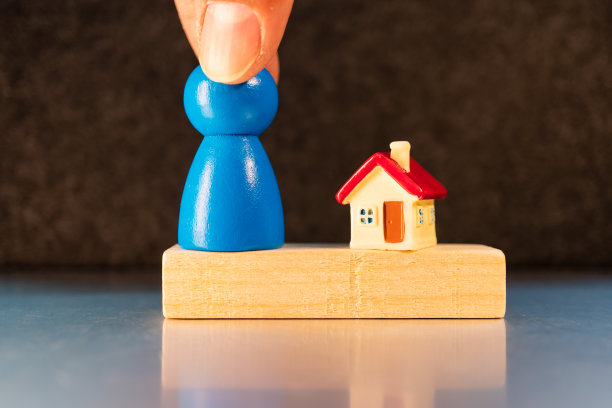 手持木头人站在迷你房子里图片下载