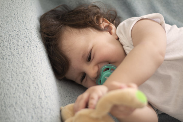 可爱的婴儿男孩躺在床上平常的照片图片下载