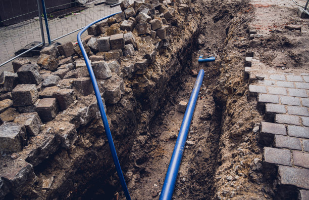 大型施工现场，施工区域有管道和电线。图片下载