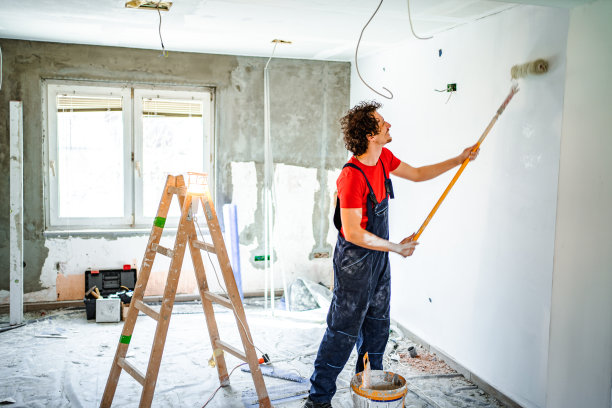 建筑工人用油漆滚筒粉刷公寓墙壁图片下载