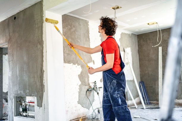 建筑工人用油漆滚筒粉刷公寓墙壁图片下载