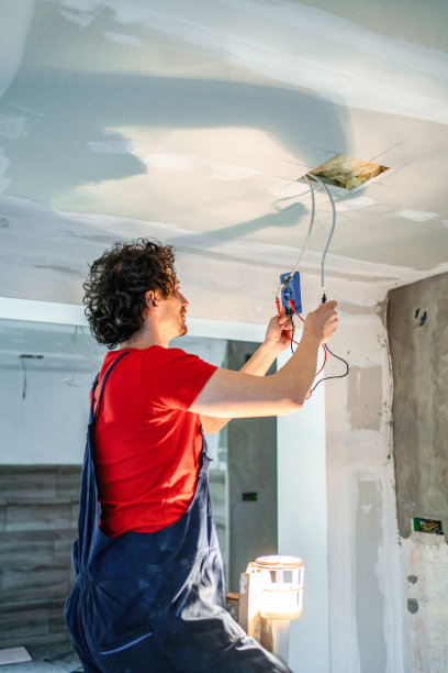 电工在装修房子时把电线固定在天花板上图片下载
