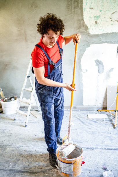 建筑工人用油漆滚筒粉刷公寓墙壁图片下载