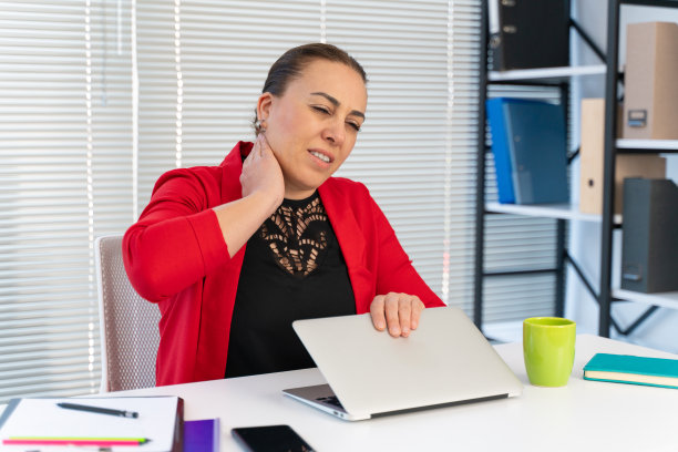 女商人在家里工作时，因颈部疼痛而揉脖子图片下载