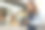 年轻女子专注地看着她的专业相机在模糊的背景灯光。图片下载