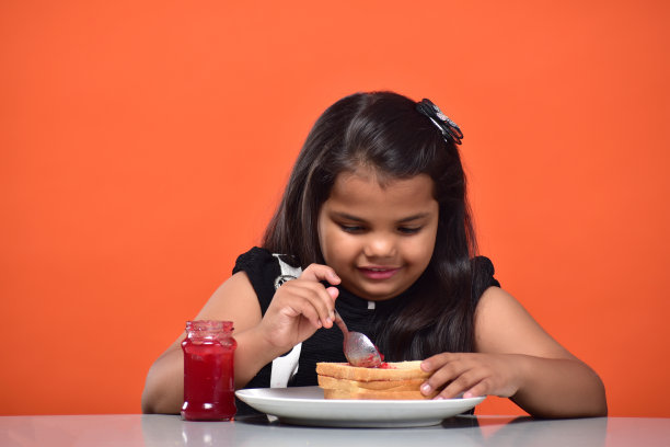 小女孩拿着面包和果酱的图片图片下载