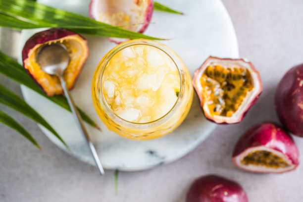 一杯冰百香果苏打水，加柠檬和半片百香果，淡色背景，清爽饮料或加冰饮料图片下载