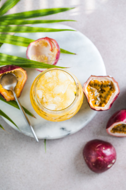 一杯冰百香果苏打水，加柠檬和半片百香果，淡色背景，清爽饮料或加冰饮料图片下载