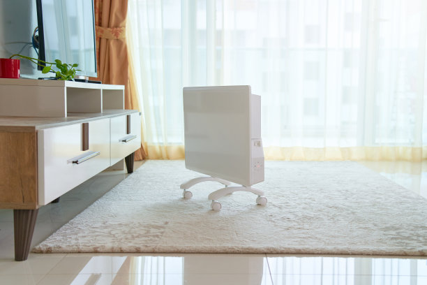 客厅地板地毯上的现代白色便携式电暖器图片下载