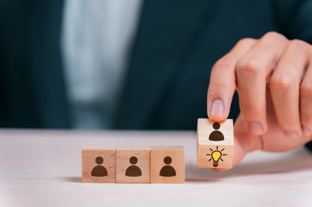 领导者选择最好的新想法与木块上的灯泡图标。探索创意设计，解决方案，策略审查。鼓励创新和团队合作。图片下载