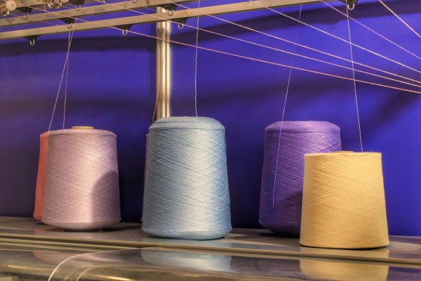 纺纱机彩色线线轴特写。纺织厂的纱筒制造。服装行业绣花机。染色织物纱线。缝制料工具图片下载