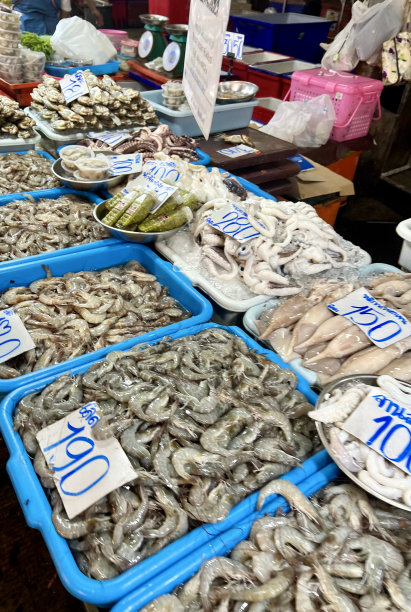 一张桌子上放着海鲜托盘的照片，在市场上展示海鲜，背景是人图片下载