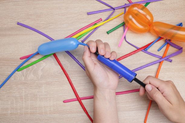 手里拿着气泵，给气球充气，用于制作工艺品、玩具图片下载