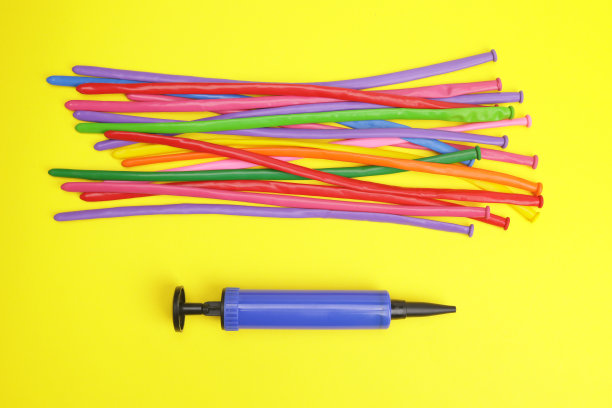 黄色背景上的气泵和气球图片下载