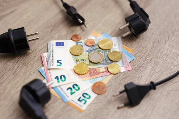 电力成本和昂贵的能源概念-电力供应电源线插头与欧元钞票和硬币图片下载