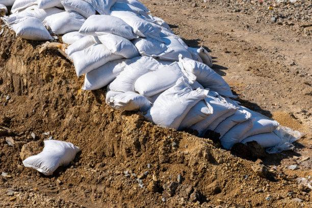 外面有一堆装水泥和沙子的袋子。建筑材料。建筑。图片下载