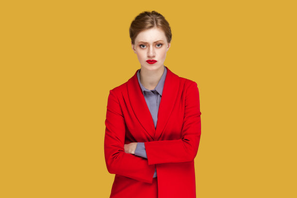 严肃严厉的女人抱着双臂站着，看着镜头，带着一种专横的表情图片下载