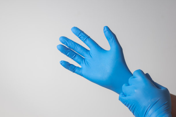 男性手戴蓝色乳胶手套，医用，防护，白色背景图片下载
