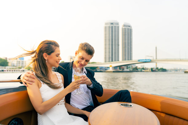 一对高加索夫妇在城市里乘坐私人游艇在河上旅行。图片下载
