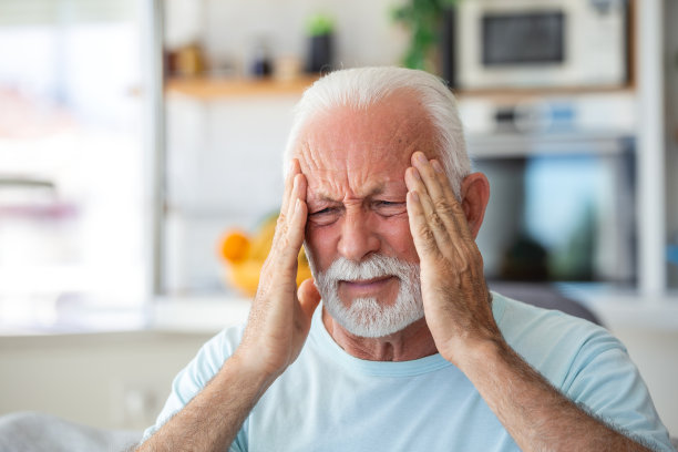 老人在家里头痛。忧心忡忡的老人独自坐在家里。头痛真疼。我的头疼死了图片下载