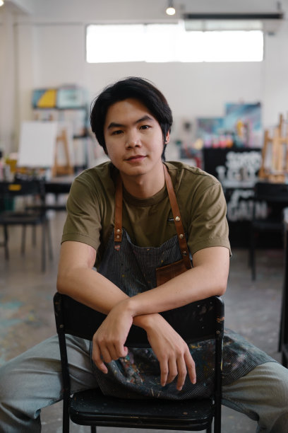 坐在艺术工作室里的英俊男艺术家的肖像图片下载