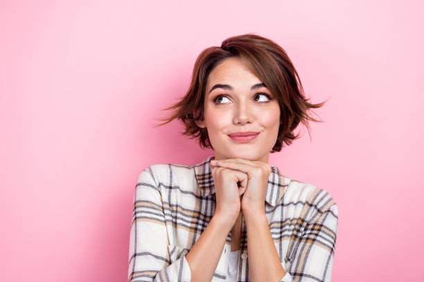 照片中若有所思的漂亮女士穿着格子夹克，手臂上的下巴看起来空白，孤立的粉红色背景图片下载