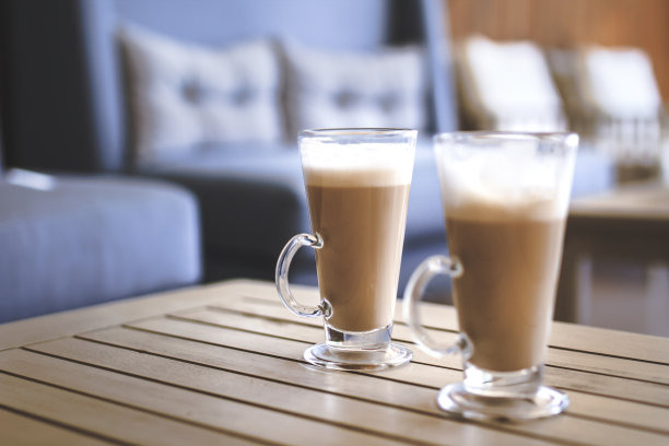 咖啡桌上美味的拿铁玛奇朵，上面有泡沫和肉桂图片下载