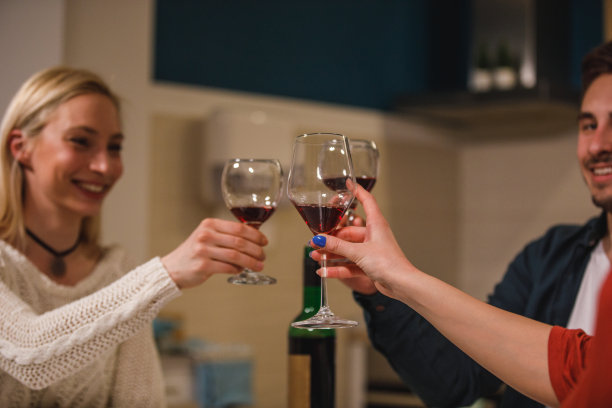 三个朋友在庆祝晚宴上喝着红酒欢呼图片下载
