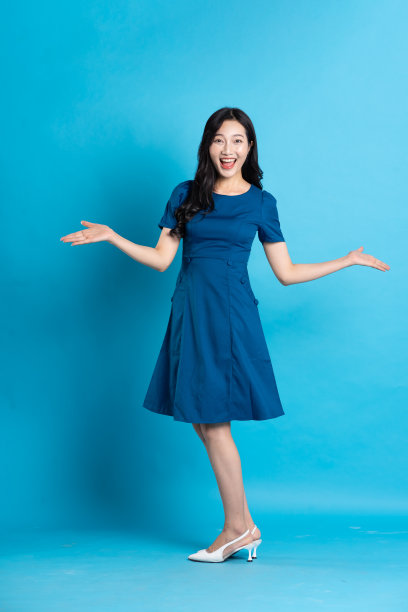在蓝色的背景上，一个穿着蓝色裙子的美丽女人的肖像图片下载
