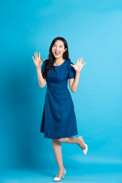 在蓝色的背景上，一个穿着蓝色裙子的美丽女人的肖像图片下载