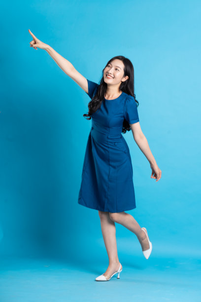 在蓝色的背景上，一个穿着蓝色裙子的美丽女人的肖像图片下载