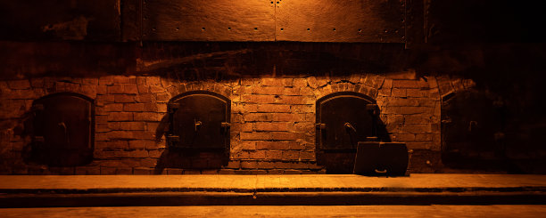 昏暗的废弃工厂或地堡的铁门或城堡或堡垒的旧砖墙上的大门被阴暗的戏剧性的光线照亮。图片下载