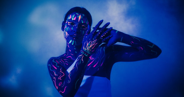 一个年轻的女舞者的抽象现代舞表演肖像在黑暗的风景舞台与彩色背景艺术。创新和电影的照片与一个有创意的嬉皮女孩与身体艺术图片下载