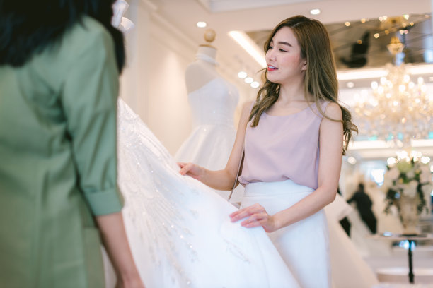 新娘店女老板在婚庆工作室工作。新娘婚纱店老板在店里工作。女设计师在店里制作婚纱。图片下载