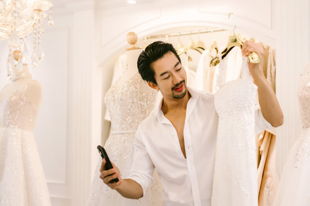 新娘和新郎在商店挑选结婚礼服。新娘和新郎选择礼服，并尝试在现代婚礼工作室图片下载