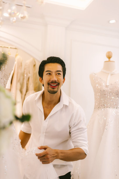 新娘和新郎在商店挑选结婚礼服。新娘和新郎选择礼服，并尝试在现代婚礼工作室图片下载